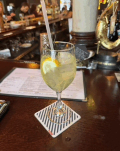 Limoncello spritz cocktail with lemon slice served in a wine glass at a bar