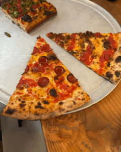 pizza slices served on a metal plate at a New York City pizzeria