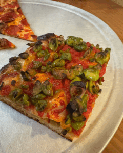 Sicilian-style pizza slice topped with tomato sauce and Castelvetrano olives