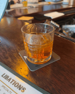 Old fashioned cocktail served in a rocks glass on a wooden bar