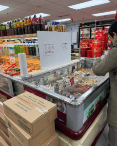 Hot pot ingredients displayed in a freezer case at an Asian grocery store in New York City