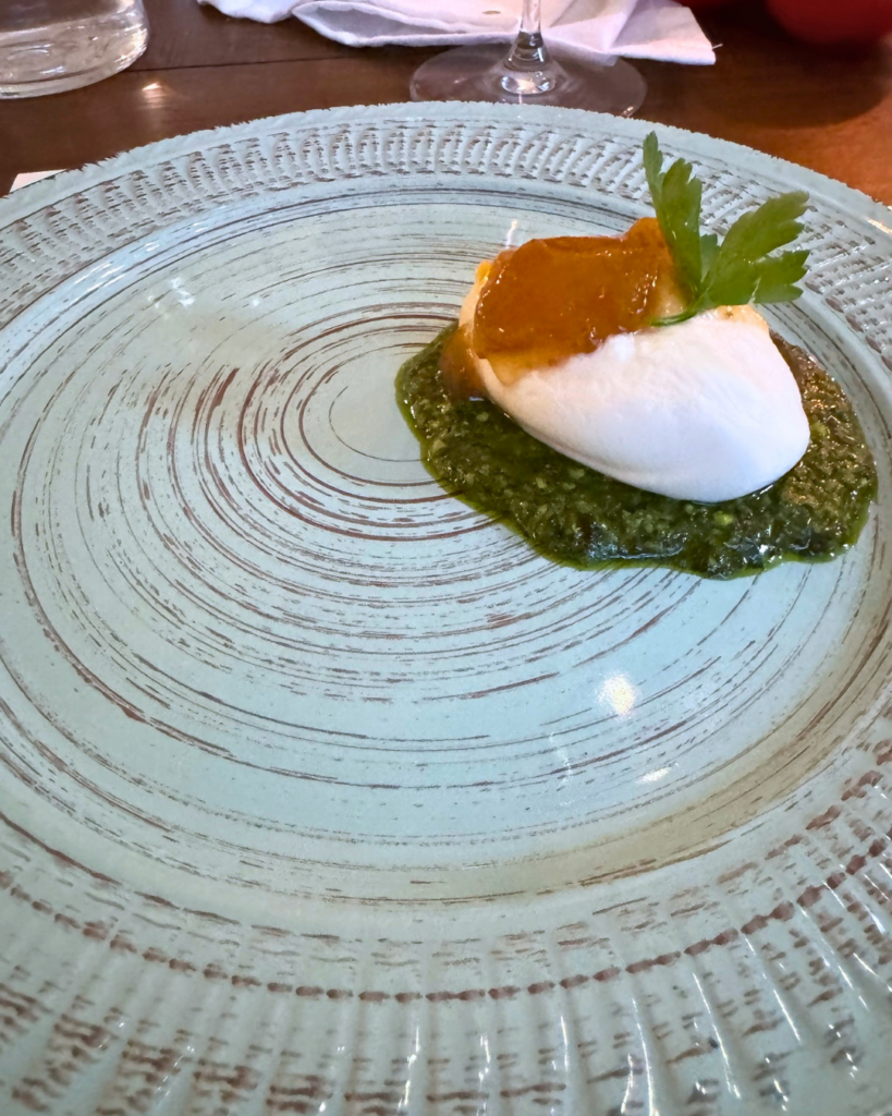 Fresh buffalo milk burrata served over fried black cabbage pesto with preserved figs at Amaro Supper Club.