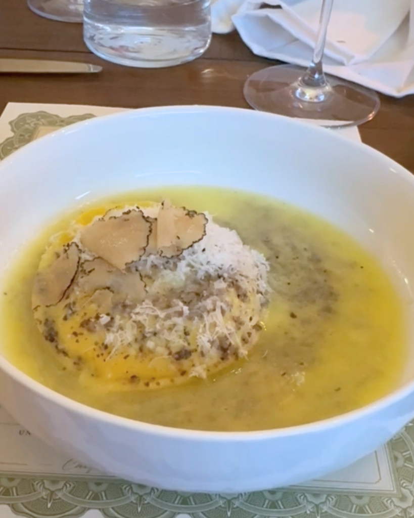 Homemade ricotta and spinach ravioli with a runny egg yolk, buffalo butter, Parmesan, and shaved black truffle at Amaro Supper Club.
